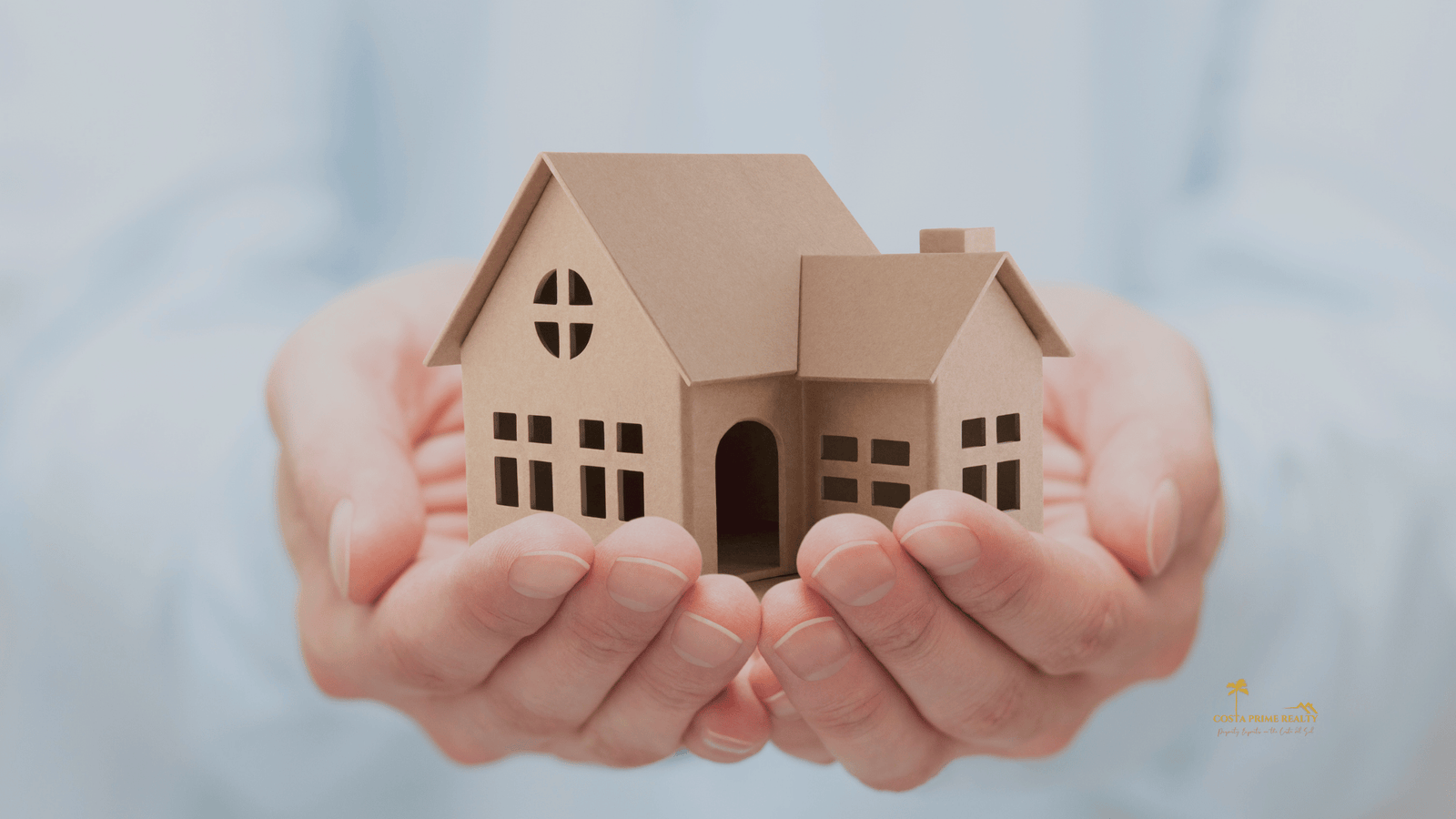 Hands holding a house model representing safe property purchase in Spain